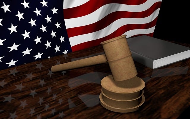 American flag behind desk with gavel and book - depicting the legal process of codifying documents
